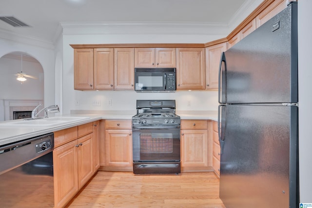 kitchen featuring ornamental molding, light brown cabinetry, sink, and black appliances