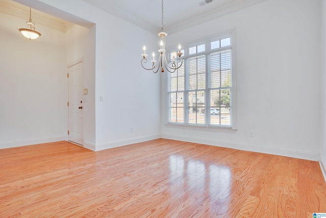 spare room with crown molding, a chandelier, and light wood-type flooring