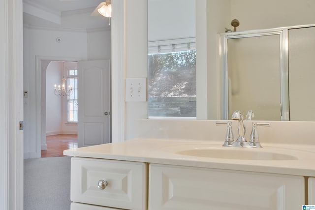 bathroom with an enclosed shower, ornamental molding, and vanity