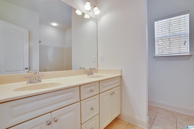 bathroom with tile patterned flooring, vanity, and walk in shower