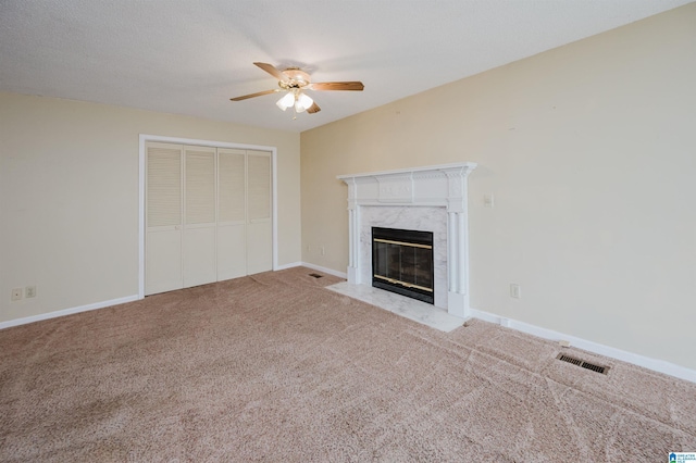 unfurnished living room featuring ceiling fan, light carpet, and a fireplace