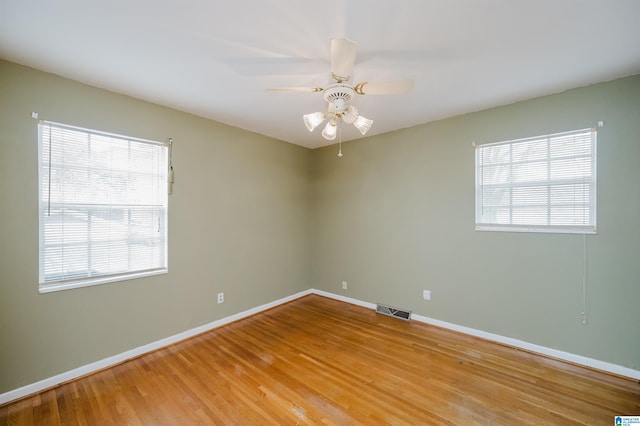 empty room featuring ceiling fan, a healthy amount of sunlight, and light hardwood / wood-style flooring