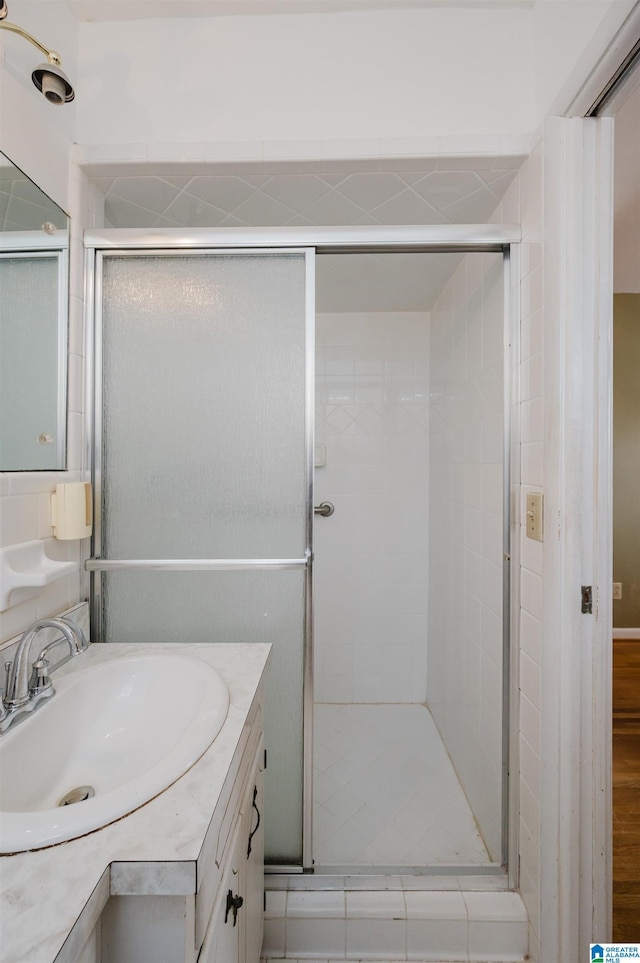 bathroom with vanity and a shower with door