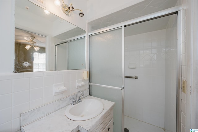 bathroom featuring tasteful backsplash, ceiling fan, vanity, and an enclosed shower