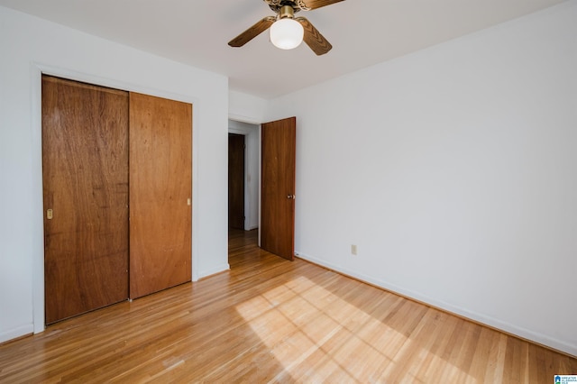 unfurnished bedroom with ceiling fan, light hardwood / wood-style floors, and a closet