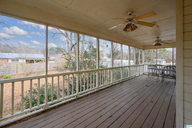 unfurnished sunroom with ceiling fan