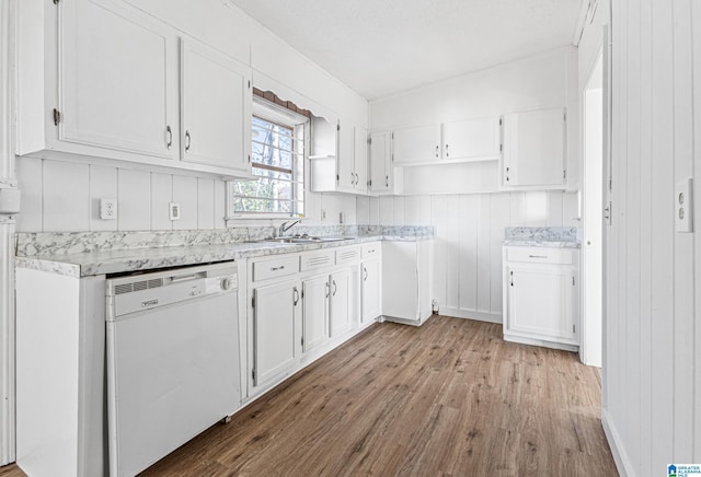 kitchen with white dishwasher, sink, white cabinetry, and light wood-type flooring