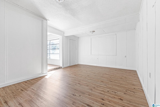 unfurnished room with wood-type flooring and a textured ceiling