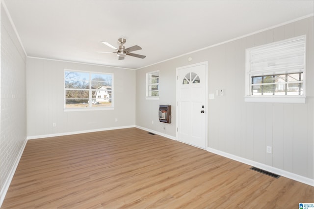 interior space featuring crown molding, ceiling fan, light hardwood / wood-style floors, and heating unit