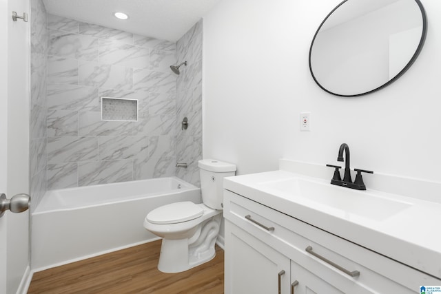 full bathroom with vanity, wood-type flooring, toilet, and tiled shower / bath