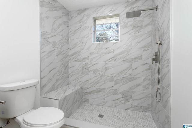 bathroom featuring tiled shower and toilet