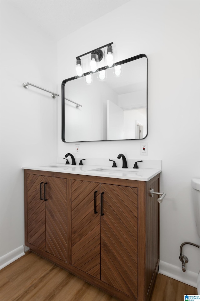 bathroom featuring vanity, hardwood / wood-style floors, and toilet