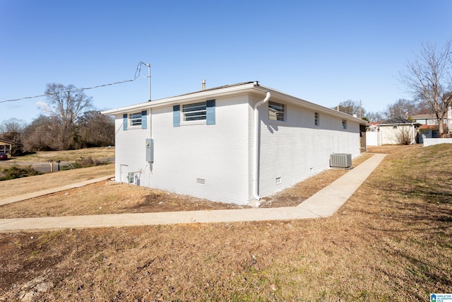 view of side of property with a yard and central AC unit