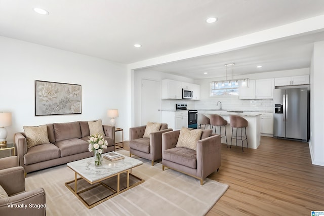 living room with sink and light hardwood / wood-style flooring