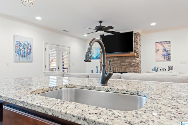 kitchen featuring sink, ceiling fan, crown molding, light stone countertops, and french doors