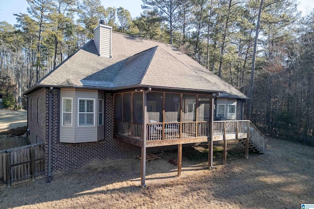 rear view of property with a deck and a sunroom