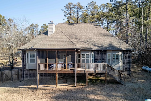 rear view of house featuring a sunroom and a deck