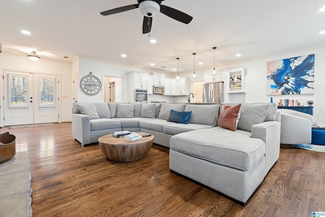 living room with sink, ceiling fan, dark hardwood / wood-style floors, ornamental molding, and french doors