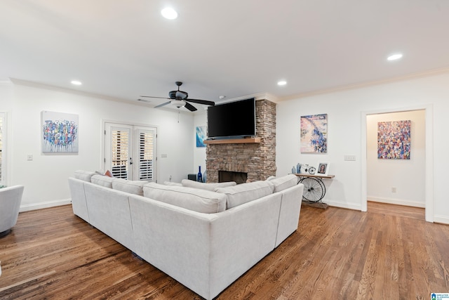 living room with a fireplace, crown molding, and wood-type flooring