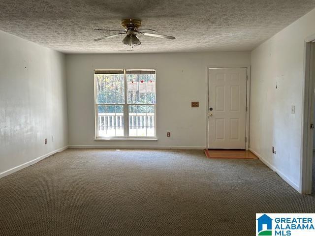 empty room with carpet, a textured ceiling, and ceiling fan