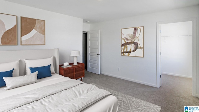 carpeted bedroom with a spacious closet and a closet