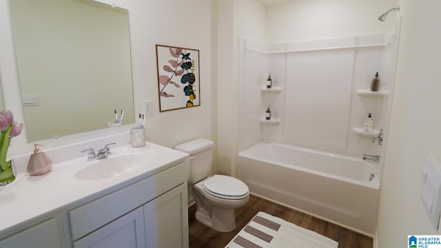 full bathroom featuring washtub / shower combination, wood-type flooring, toilet, and vanity