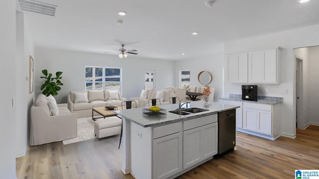 kitchen featuring dishwasher, white cabinetry, sink, and a kitchen island with sink