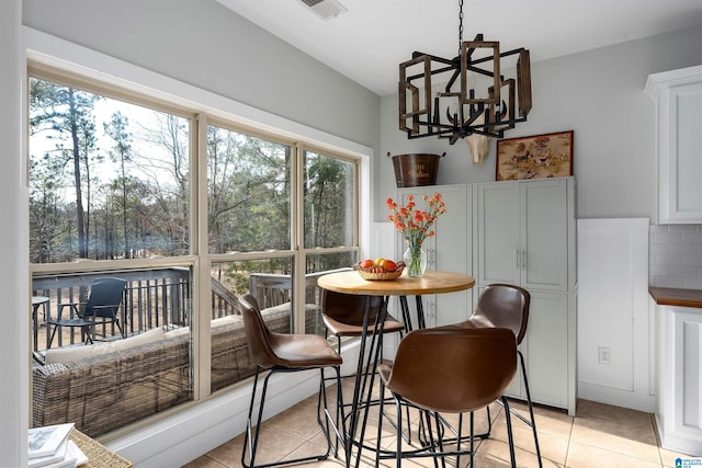 dining area with an inviting chandelier and light tile patterned floors