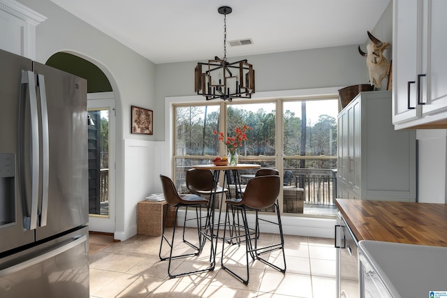 dining area with an inviting chandelier, plenty of natural light, and light tile patterned flooring