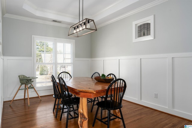 dining space featuring ornamental molding, plenty of natural light, a tray ceiling, and dark hardwood / wood-style flooring