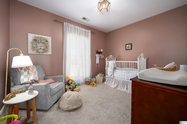 carpeted bedroom featuring a nursery area