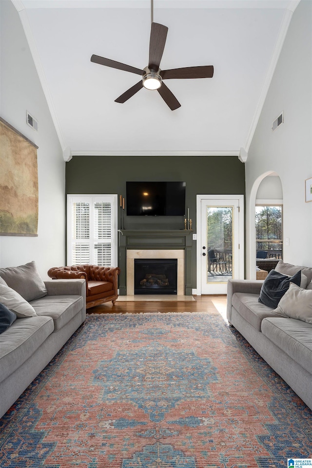 living room featuring hardwood / wood-style floors, ornamental molding, high vaulted ceiling, and ceiling fan