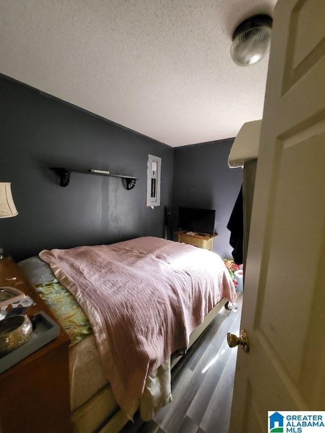 bedroom featuring hardwood / wood-style flooring and a textured ceiling