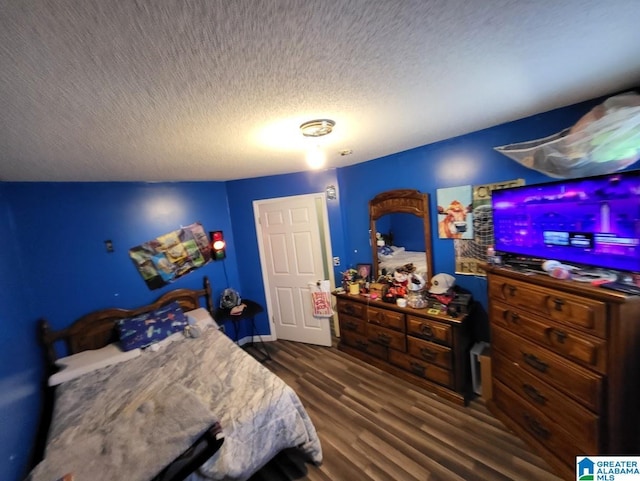 bedroom with a textured ceiling and dark hardwood / wood-style flooring