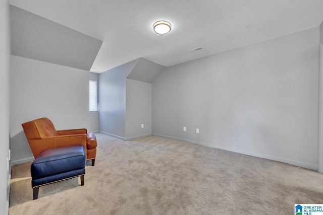 sitting room with light colored carpet and lofted ceiling