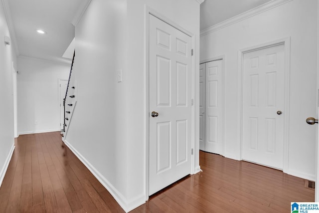 hallway with dark hardwood / wood-style flooring and ornamental molding