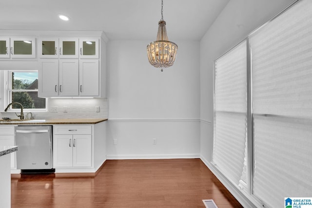 kitchen with white cabinetry, stainless steel dishwasher, decorative light fixtures, and sink