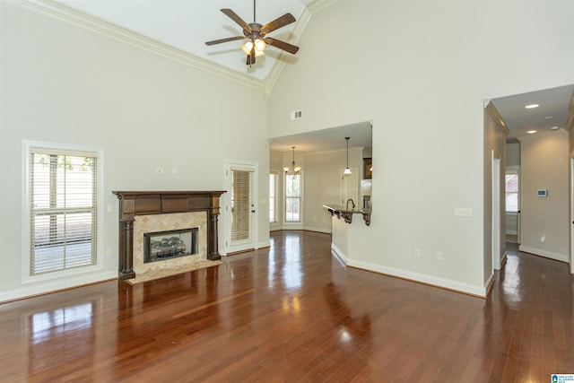 unfurnished living room featuring crown molding, high vaulted ceiling, dark hardwood / wood-style floors, and a high end fireplace