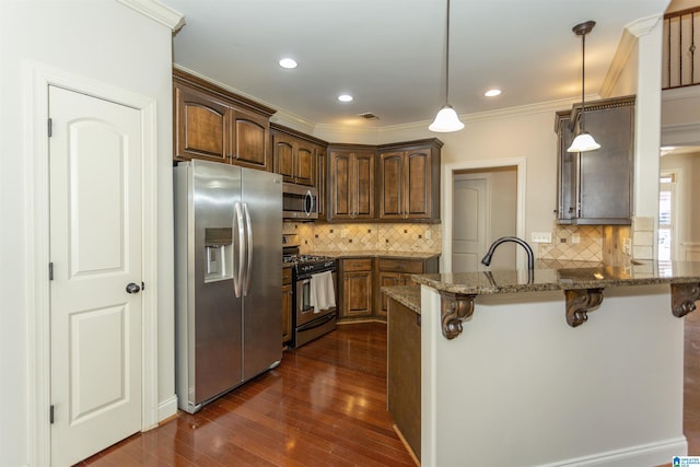 kitchen with a breakfast bar area, dark stone countertops, hanging light fixtures, kitchen peninsula, and stainless steel appliances