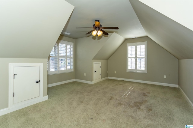 additional living space with vaulted ceiling, light colored carpet, and ceiling fan