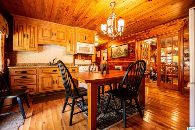 dining space featuring an inviting chandelier, sink, wooden ceiling, and light wood-type flooring