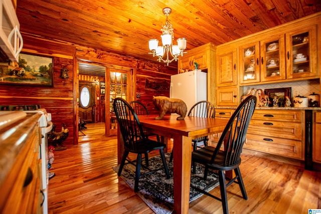 dining space with a notable chandelier, wood ceiling, and light wood-type flooring