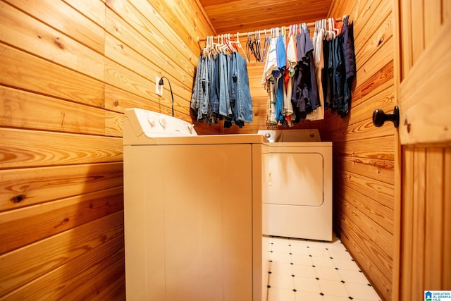 laundry area with wooden walls, wooden ceiling, and washer and clothes dryer