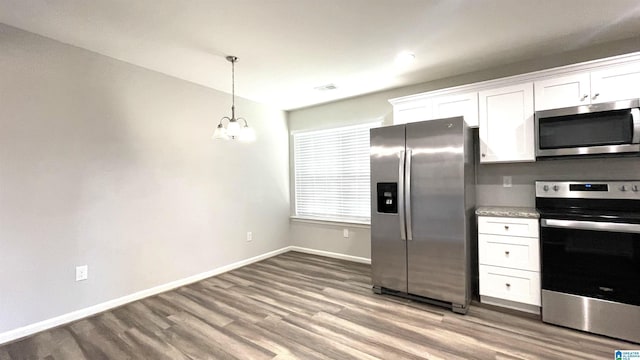 kitchen with decorative light fixtures, white cabinetry, a chandelier, hardwood / wood-style flooring, and stainless steel appliances