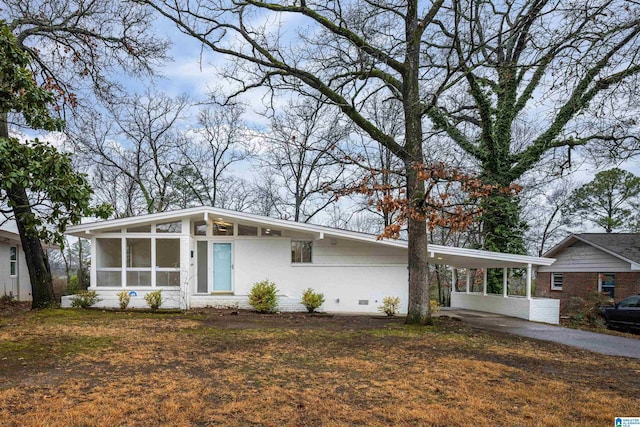 single story home featuring a carport and a sunroom