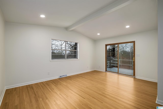 spare room featuring lofted ceiling with beams and light hardwood / wood-style floors