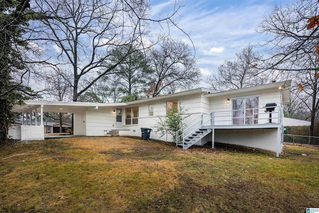 rear view of house featuring a carport and a lawn