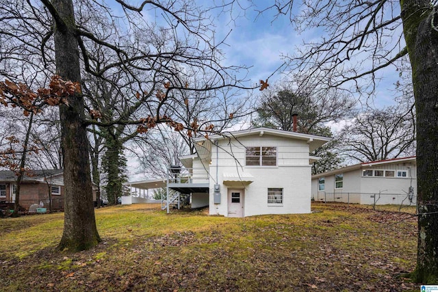 back of property with a yard and a deck