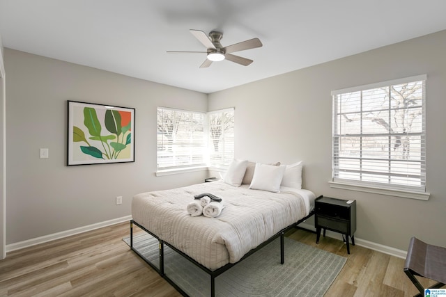 bedroom with multiple windows, ceiling fan, and light hardwood / wood-style flooring