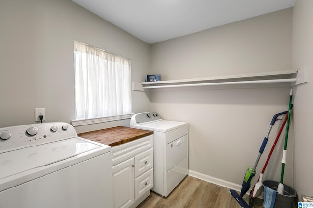 laundry room featuring cabinets, washer and dryer, a wealth of natural light, and light wood-type flooring